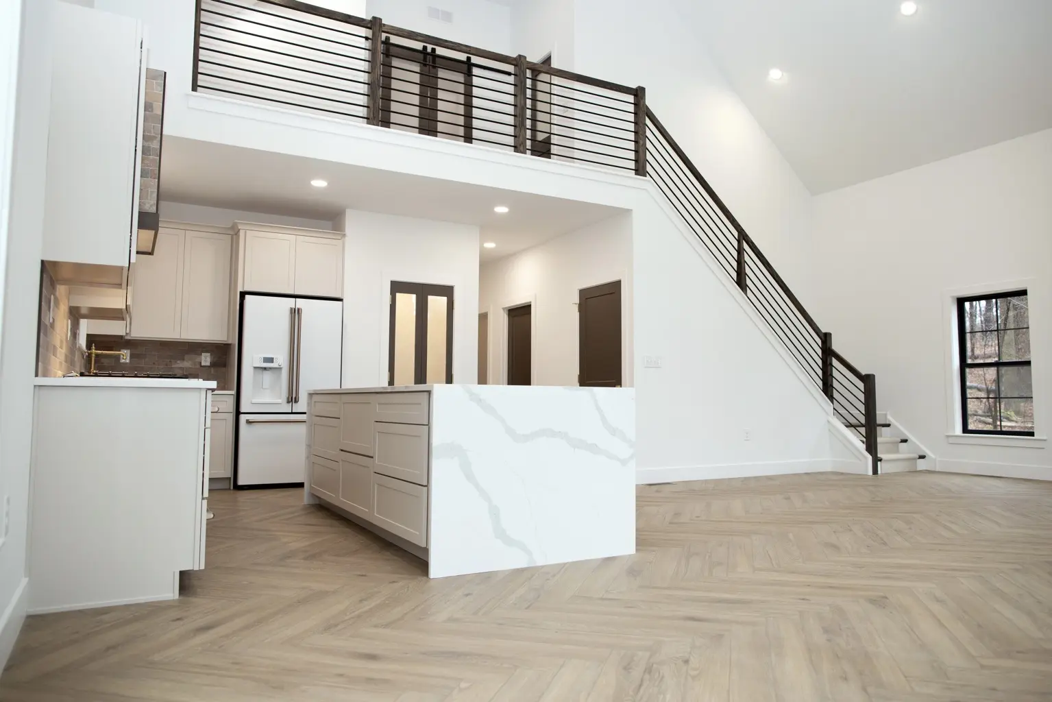 Completed custom home interior with a loft, staircase, and kitchen